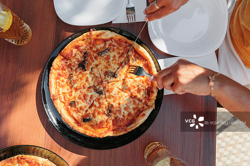 阳光明媚的桌子上切好的比萨饼图片素材