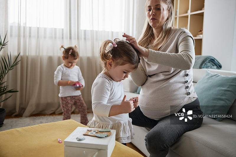 美丽的孕妈妈照顾她的女儿们图片素材