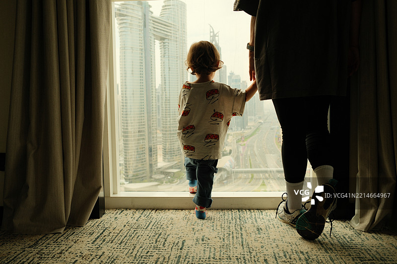 母亲和孩子在酒店房间里欣赏迪拜城市风景图片素材
