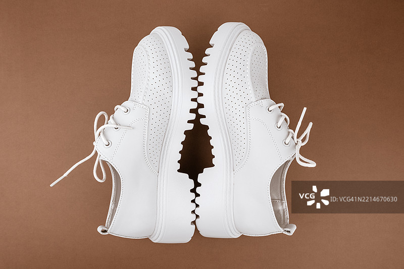 棕色背景上的鞋子。新鞋。图片素材
