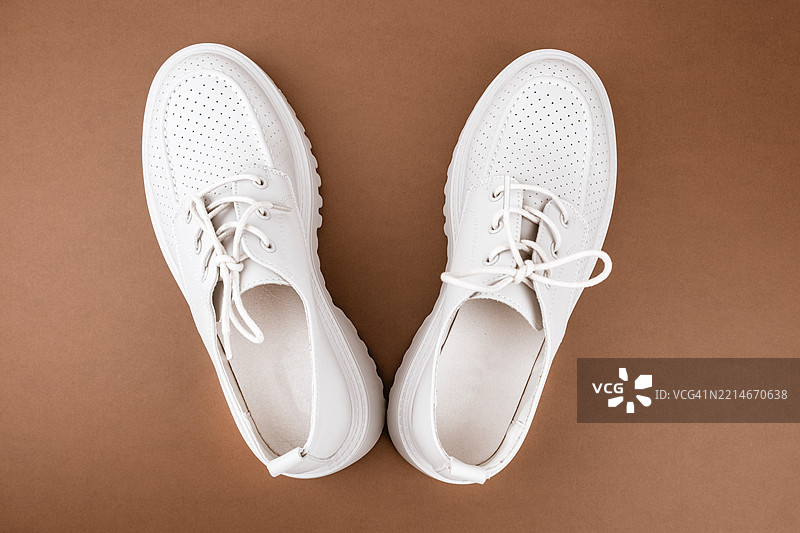 棕色背景上的鞋子。新鞋。图片素材