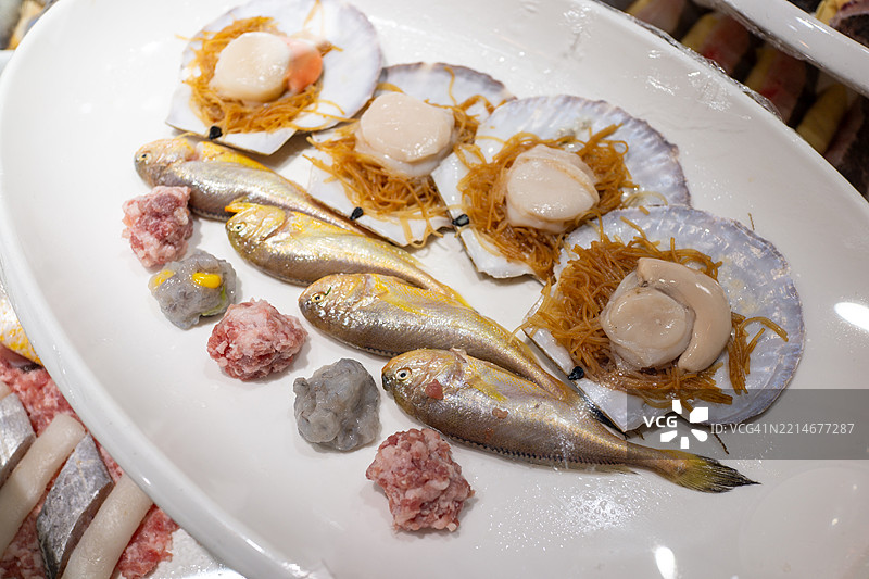 扇贝和黄花鱼在海鲜展示架上的二重奏图片素材