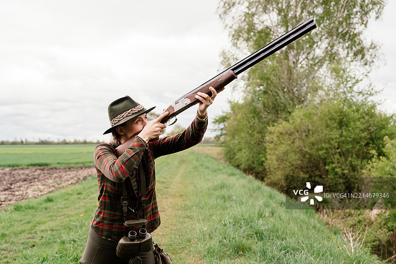 女性猎人举枪指向天空进行狩猎图片素材