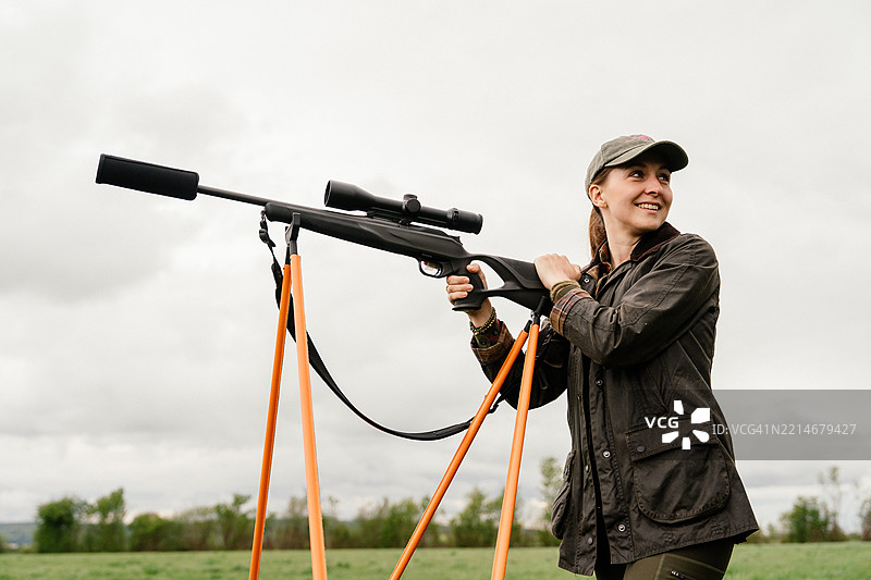 现代枪械的女性猎人观察周围环境图片素材
