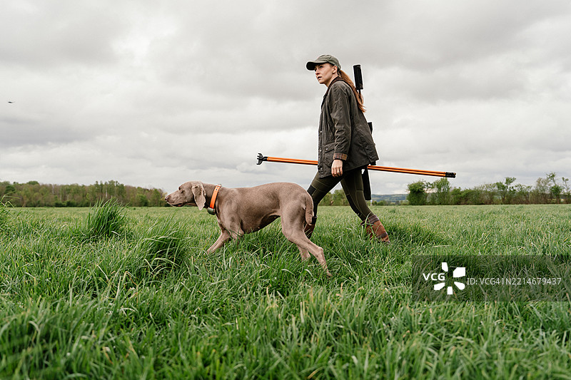 女猎人带着她的狗观察周围环境图片素材