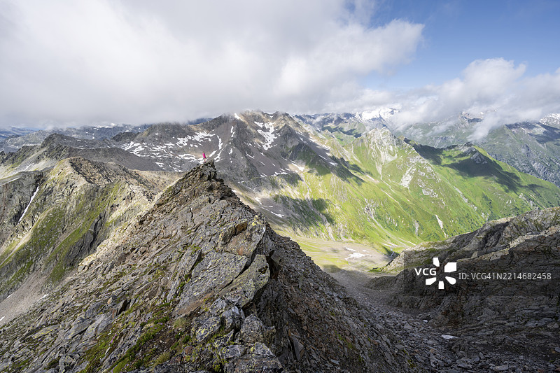 登山者在陡峭的岩石山脊上，站在拉索尔林峰的顶峰，俯瞰维尼迪格山群、拉索尔林山群和高塔恩国家公园的山脉全景，东蒂罗尔，蒂罗尔，奥地利，欧洲图片素材