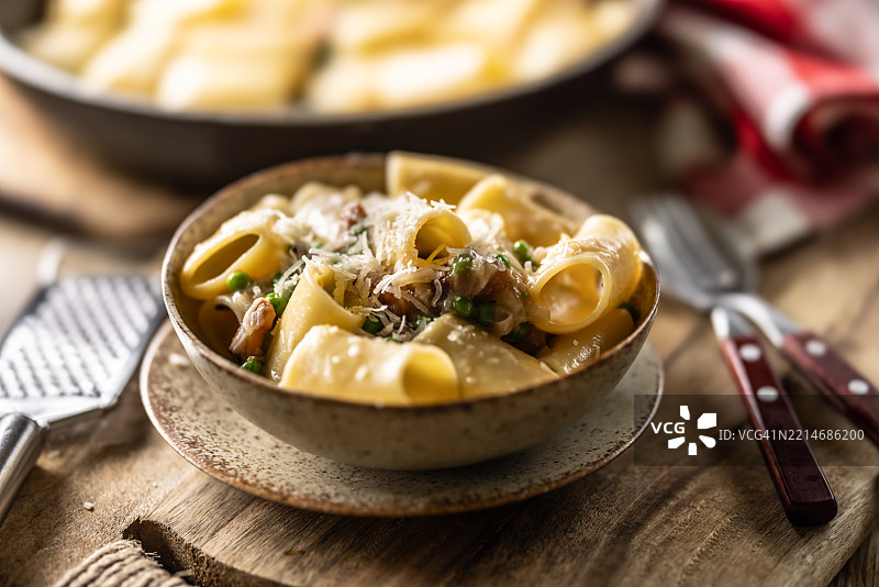 典型的意大利面卡拉马拉塔配培根、新鲜豌豆和帕尔马干酪。图片素材