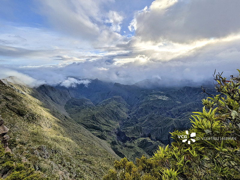 广阔的山脉覆盖着生机勃勃的绿意，云雾缭绕，位于法国留尼旺岛，非洲。图片素材