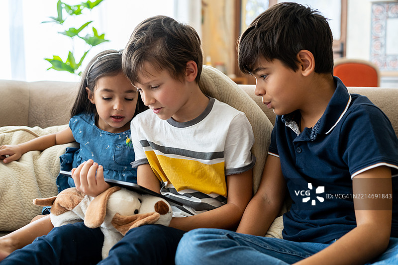 朋友和兄弟姐妹一起使用平板电脑图片素材