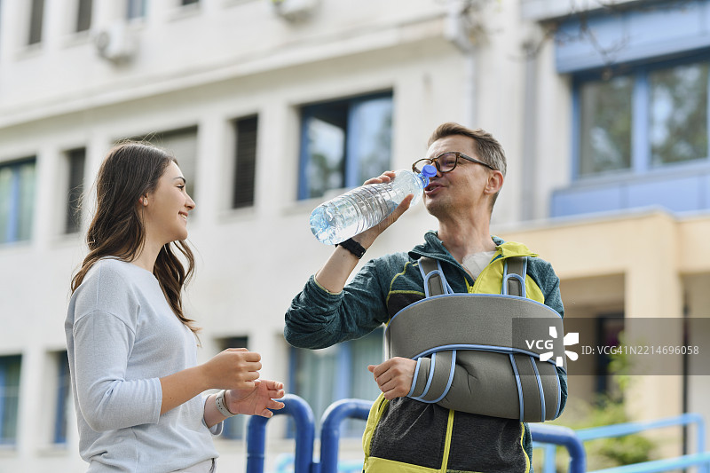 女性在观察她受伤的亲属喝水，看看他是否需要帮助。图片素材