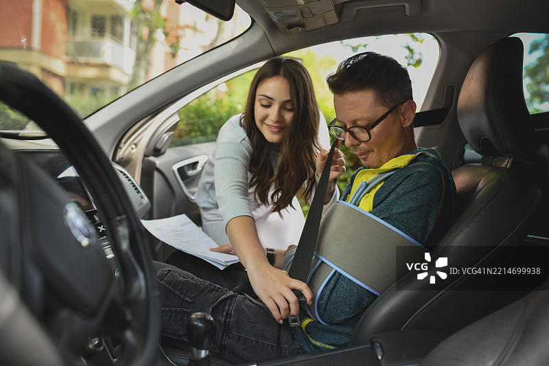 关心的女性在车内为受伤的家人系安全带图片素材