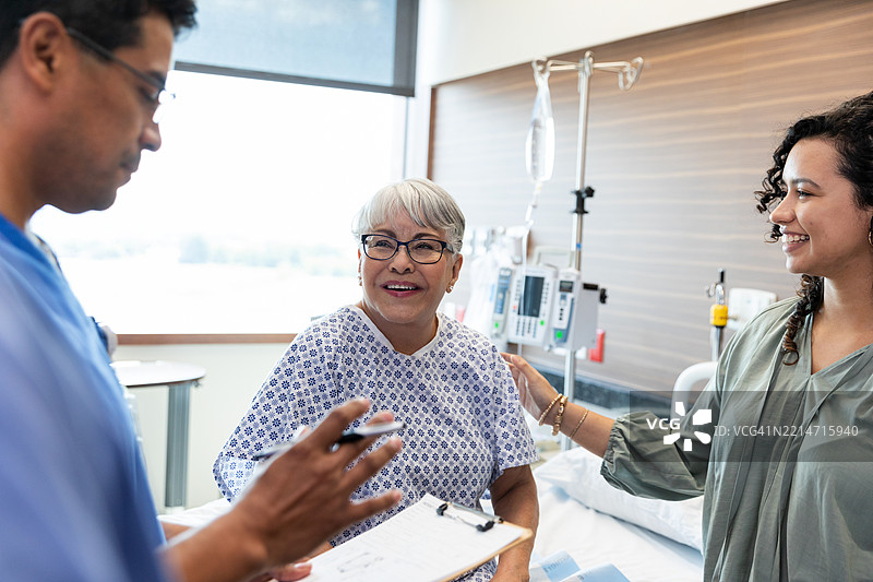 医院病房中与医生和家人一起的快乐病人图片素材