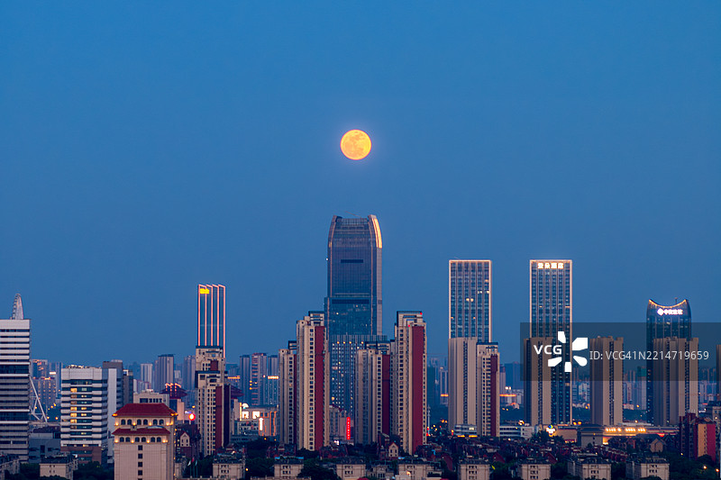 中国的城市夜景，高楼大厦与远处的月亮图片素材
