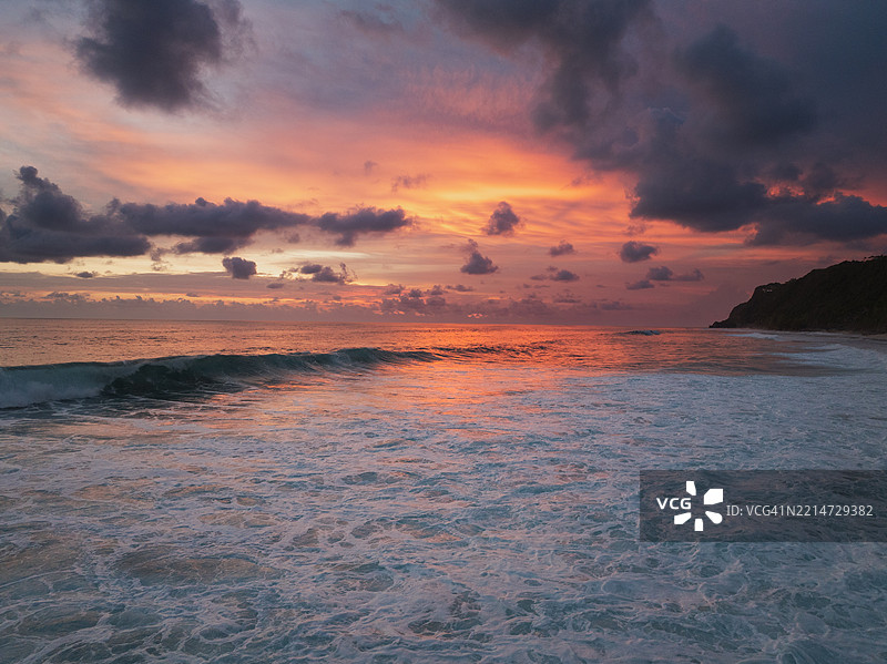 从印度洋上空拍摄的巴厘岛乌鲁瓦图海岸日落景象图片素材