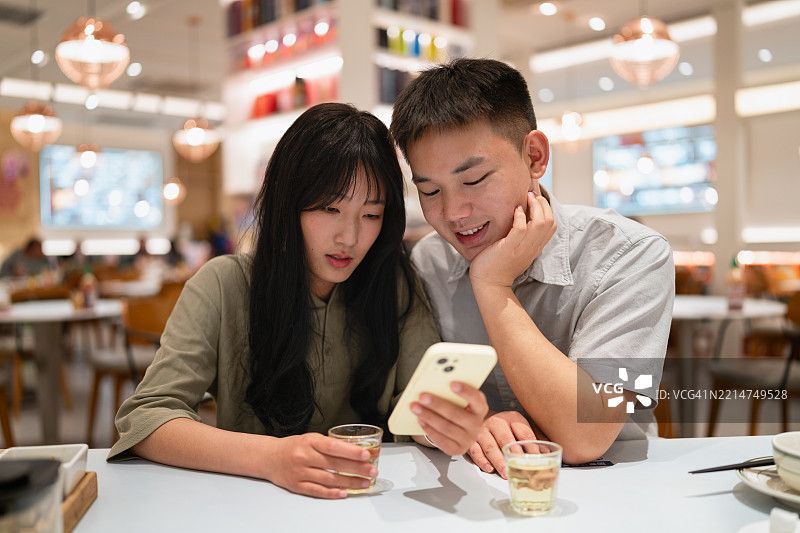 年轻的亚洲情侣在餐厅享受饮品并分享美好时光图片素材