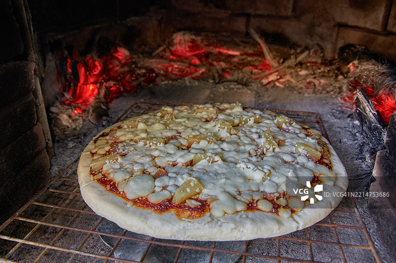 乡村烹饪：木火砖炉中的比萨饼图片素材