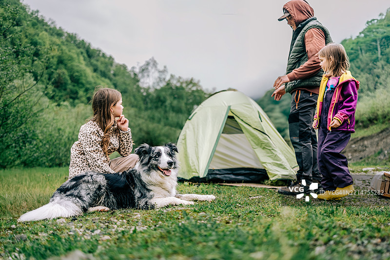 一家人在森林里与他们的狗一起享受露营时光图片素材