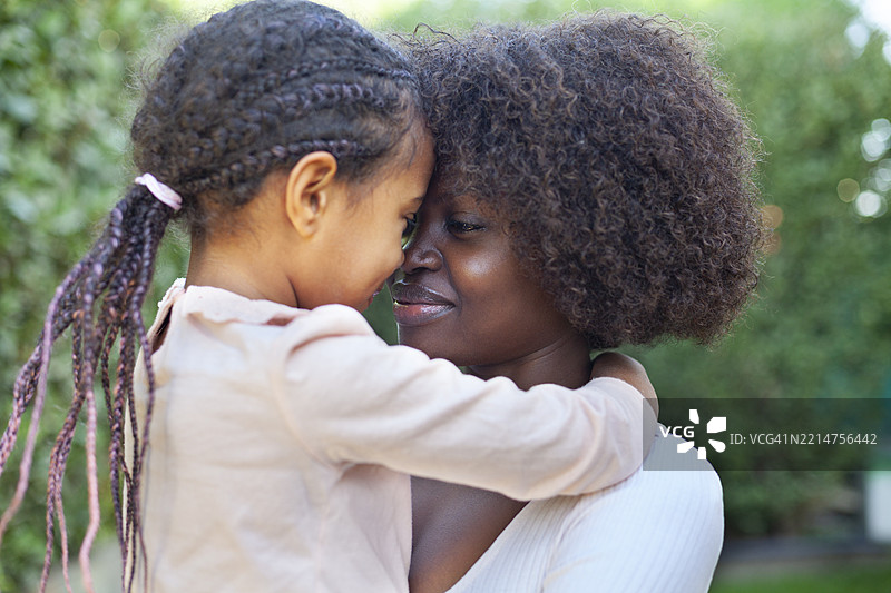 春季肖像：非洲母亲在后院拥抱她的孩子图片素材