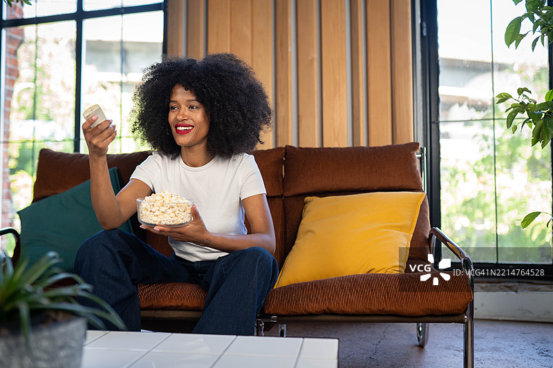 女人吃着爆米花看电视图片素材