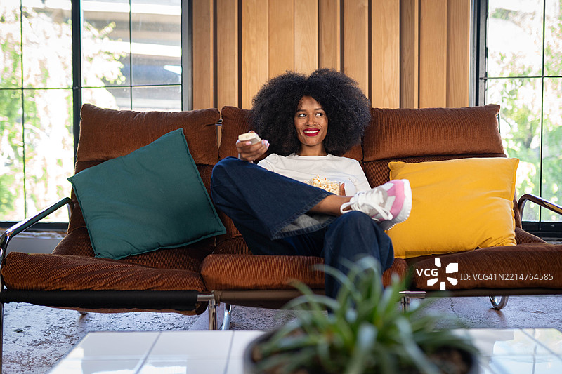 女人吃着爆米花看电视图片素材