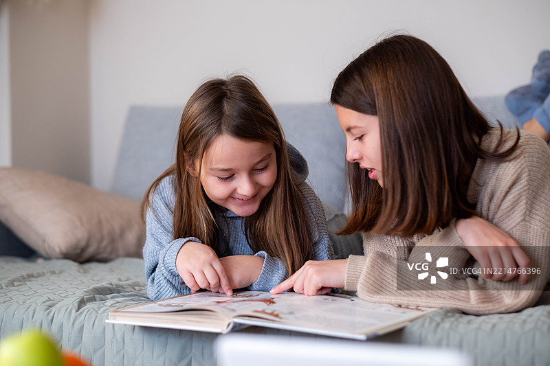 姐姐在家里帮助弟弟做作业图片素材