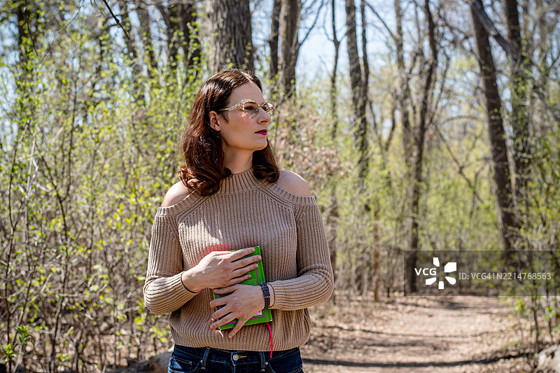 手中拿着一本好书的悠闲散步图片素材