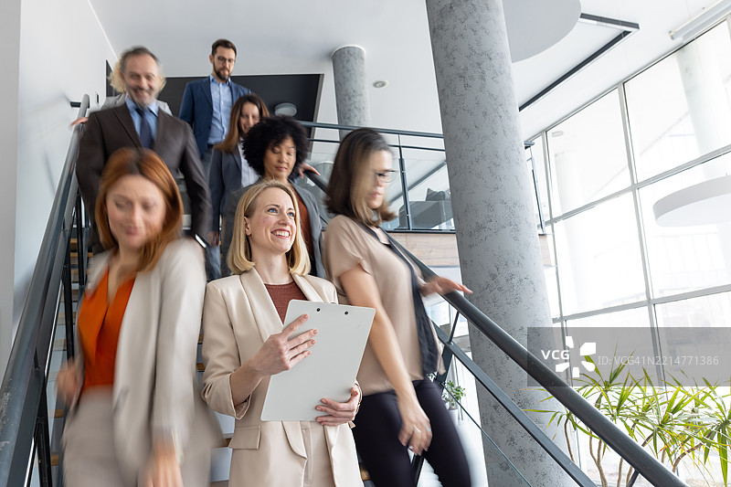 专业人士在楼梯上移动，准备进行办公室工作图片素材