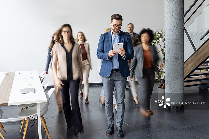 商务专业人士在现代办公空间中行走图片素材