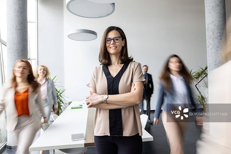 微笑的女商人在办公室自信地站着图片素材