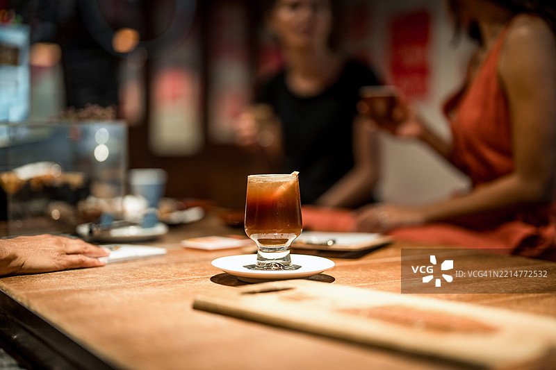 优雅的咖啡杯静静地放在温暖灯光下的木质台面上图片素材