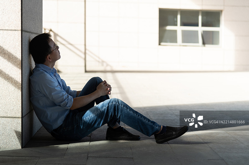 坐在地板上的伤心男人图片素材