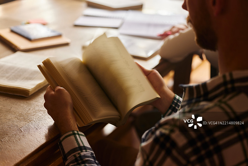 不明身份的学生在翻阅书籍的特写镜头。图片素材