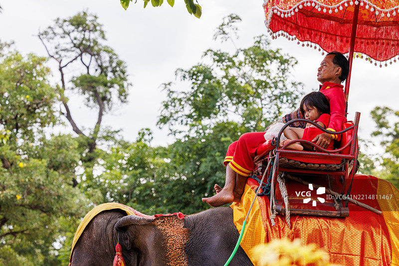 骑在大象上的驯象师与孩子，泰国阿育他亚。图片素材