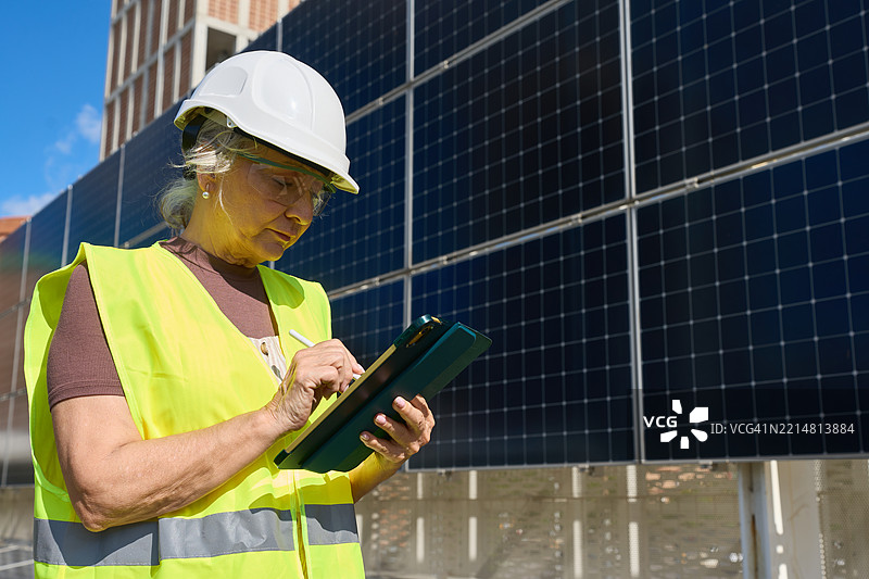 女性工程师使用数字平板检查太阳能电池板图片素材