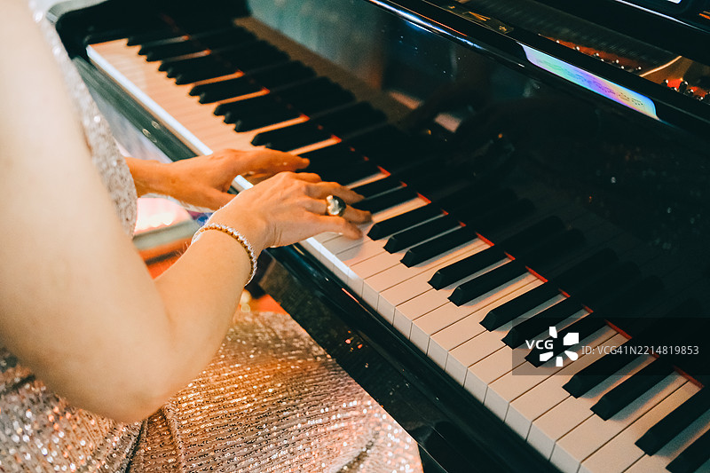 女人在演奏钢琴。图片素材