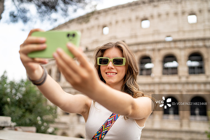 微笑着在古罗马斗兽场前自拍的女性图片素材
