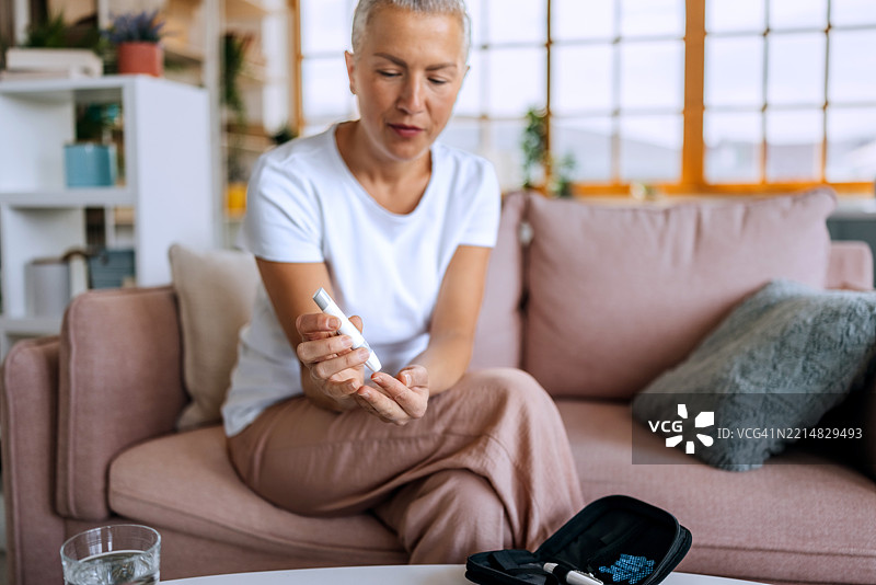 女性在家中检查血糖水平图片素材