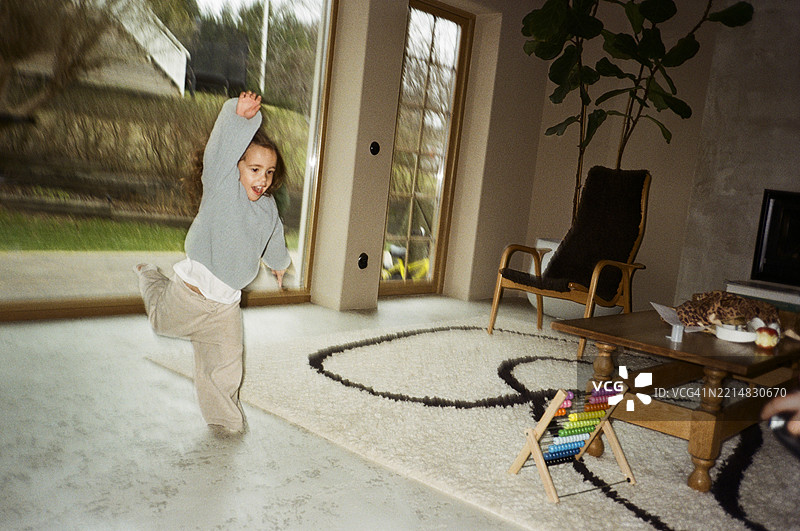 无忧无虑的女孩在家里的客厅玩耍图片素材