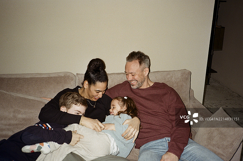 父母在家沙发上与孩子们共度闲暇时光图片素材