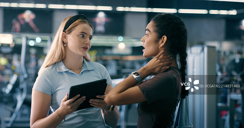 健身教练，女性与平板电脑在健身房进行计划支持，讨论身体目标或锻炼。健身教练、科技与讨论锻炼、清单或健康发展在俱乐部。图片素材