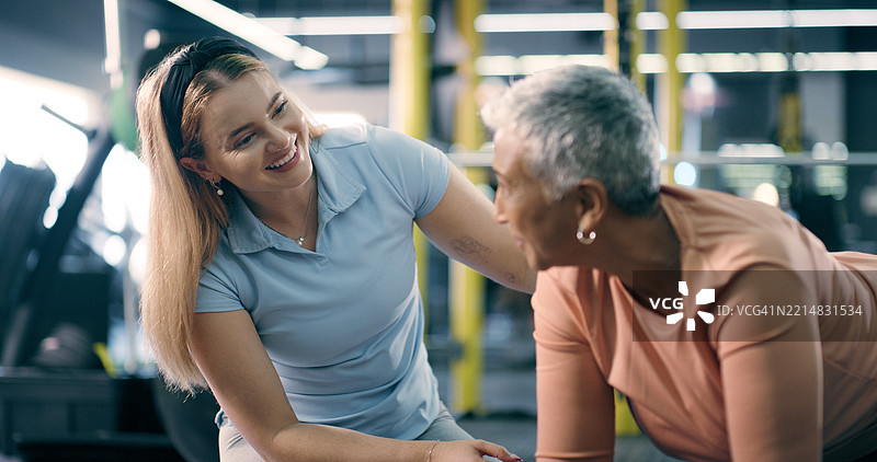 私人教练，成熟的女性在健身房做俯卧撑以获得支持，微笑或指导地在地板上锻炼。人们、教练与建议、训练和锻炼的快乐，健身俱乐部的健康交流。图片素材
