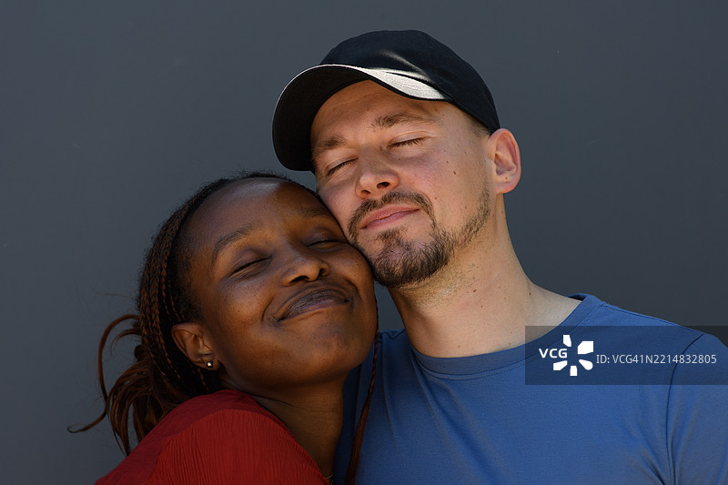 两位年轻恋人脸颊相贴，闭上眼睛。图片素材