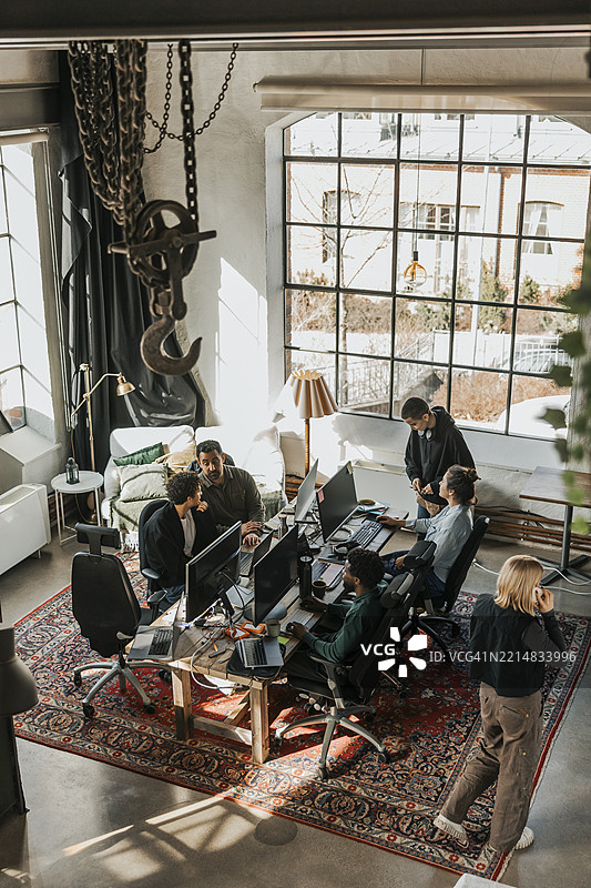 高角度视图的IT专业人士在初创公司办公室策划战略并使用台式电脑工作图片素材