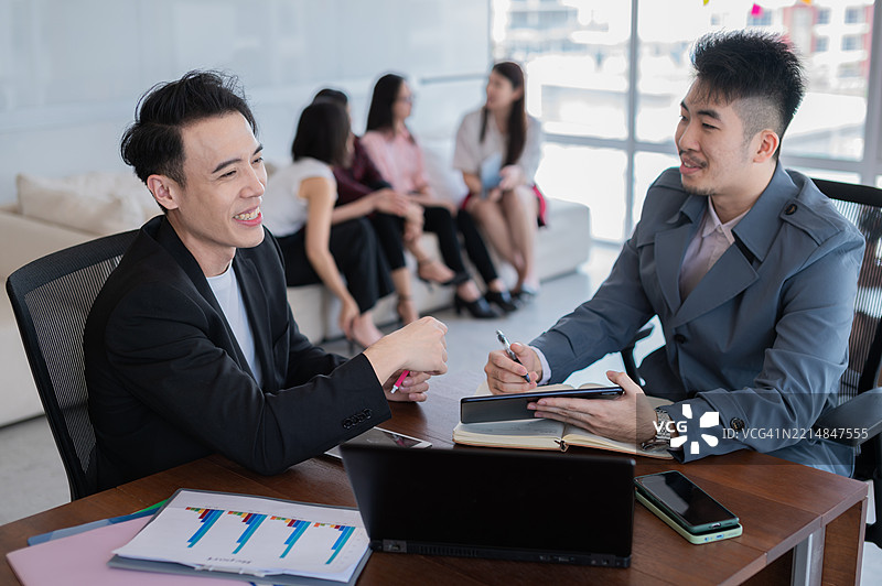 亚洲年轻成年商务员工正在讨论图表纸和数字平板，以实现项目目标预算的库存照片图片素材