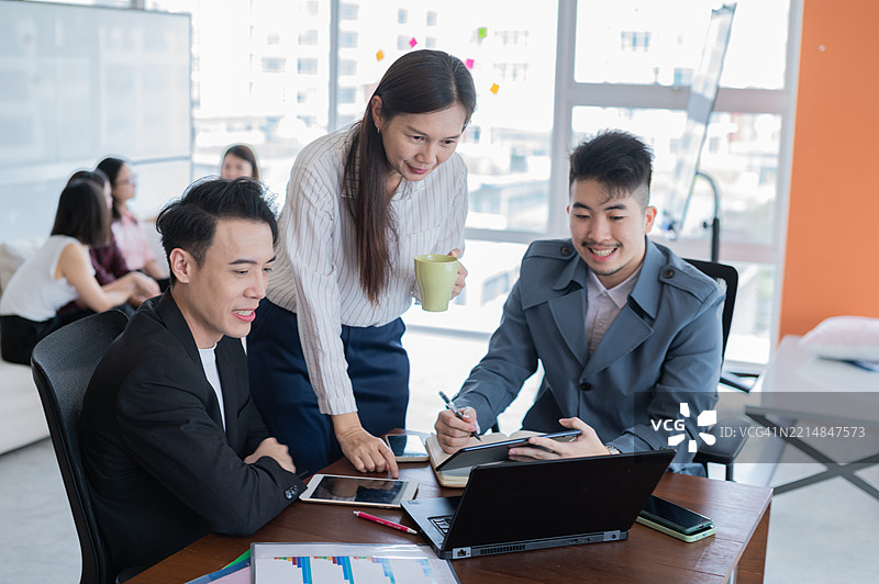 亚洲高级主管在倾听、检查并为初级员工的项目进展提供建议的照片图片素材