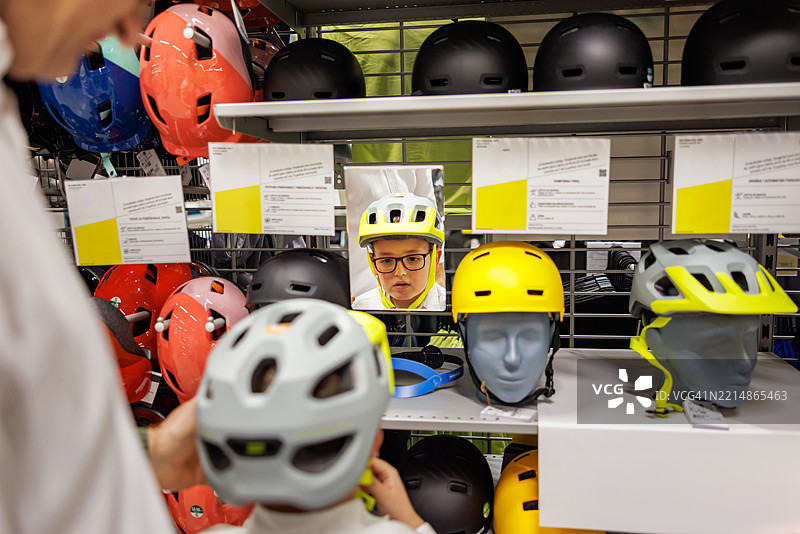 小男孩在挑选自行车头盔图片素材