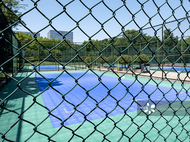 透过栅栏网格看到的户外网球场图片素材
