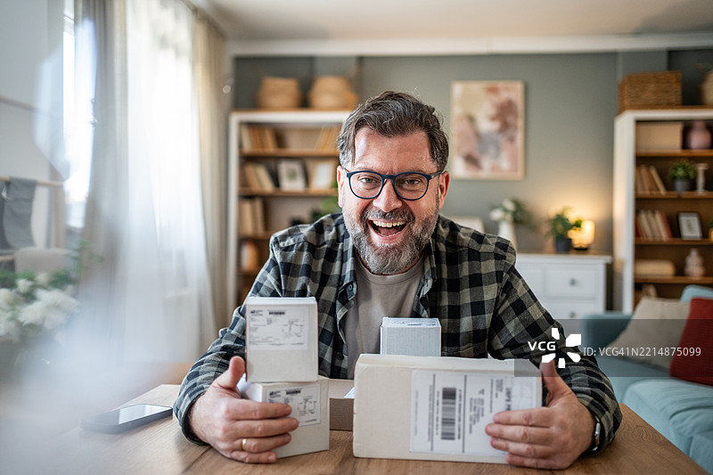 快乐的顾客在家展示网上购物的包裹箱图片素材