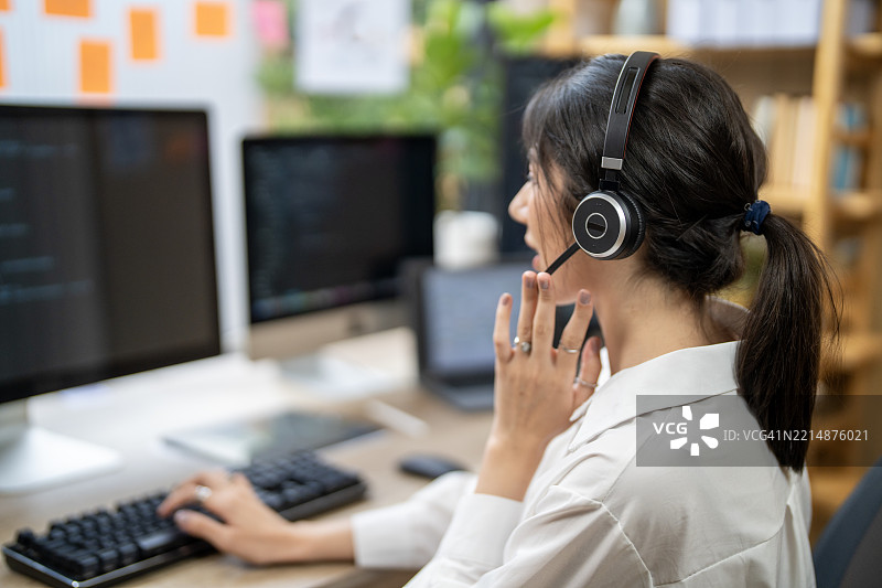 现代办公室环境中佩戴耳机的客户支持专员图片素材