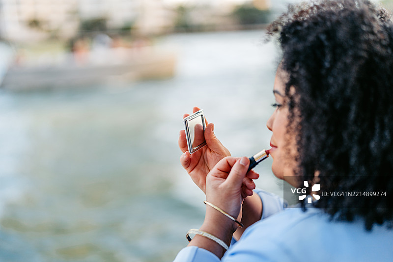 中年丰满的非裔美国女商人在迈阿密市中心的码头上涂口红图片素材
